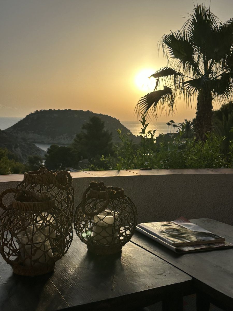 Le soleil se levant sur la mer, avec les lanternes de la terrasse au premier plan