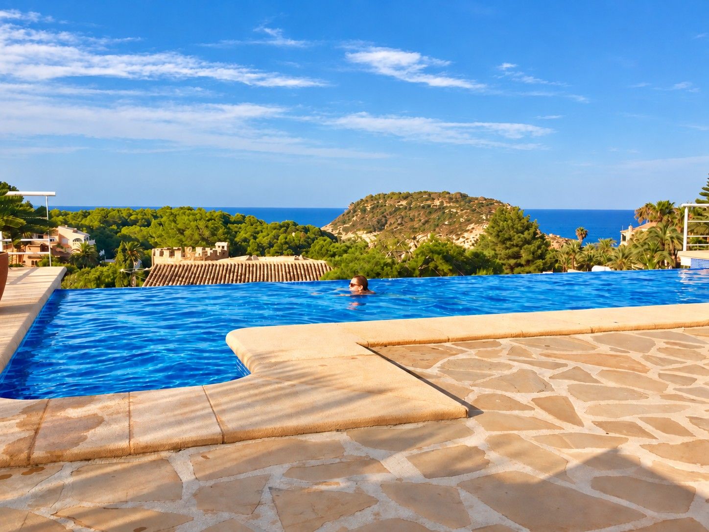 La piscine à débordement de Casa Bonita, avec l'île du Portitxol et la mer en arrière-plan